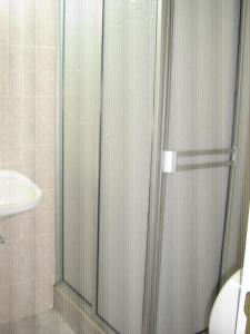 a shower with a glass door in a bathroom at Hotel Arpa de Aguas in Villavicencio