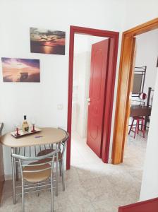 una sala da pranzo con tavolo e porta rossa di Ιno Skiathos a Città di Skiathos