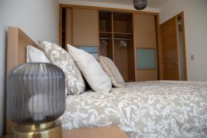 a bedroom with a bed with pillows and a lamp at VISTA MAR apartamento con encanto in Malpica +42 photos