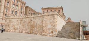 uma grande parede de tijolos com escadas em frente a um edifício em Castello Room & Spa em Cagliari
