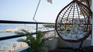 un fauteuil suspendu sur un balcon donnant sur la plage dans l'établissement KM Beach View apartment, à La Canée
