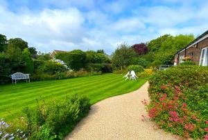 a garden with a bench and a grassy yard at The Coast Yard B & B and Garden Chalets in Chichester