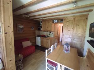 ein Wohnzimmer mit einem Tisch und eine Küche in einer Hütte in der Unterkunft Pan 125B in Manigod