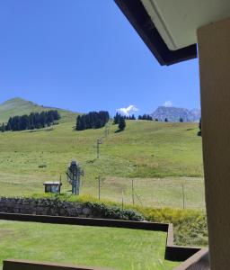 einen Blick auf ein Feld mit einem Hügel im Hintergrund in der Unterkunft Pan 125B in Manigod