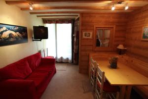 ein Wohnzimmer mit einem roten Sofa und einem Tisch in der Unterkunft Pan 125B in Manigod