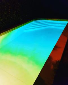 a swimming pool with blue and green illumination at Villa Capri Apartment and Room in Naples
