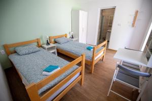 a bedroom with two beds and a table and a chair at Urban House - Ada in Ada