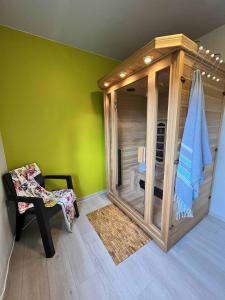 une chambre avec une douche en verre dans une pièce avec une chaise dans l'établissement sous les feuilles Redu, à Redu