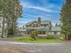 Casa blanca grande con techo verde en The Chinook Lodge at Government Camp - Meredith Lodging, en Government Camp