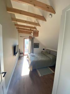 una camera con un letto in una stanza con pavimenti in legno di Pape Apartament a Pape