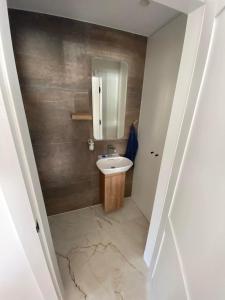 a bathroom with a sink and a mirror at Pape Apartament in Pape +7 photos