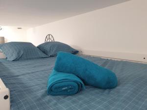 a blue blanket laying on top of a bed at Les Cigalons in Marseille