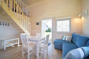 a living room with a table and a blue couch at Domki na Horyzoncie - Anna Budny in Trzebusz