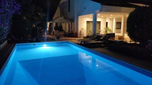 a swimming pool with blue lighting in a yard at night at B&B Apulia Time in Bari