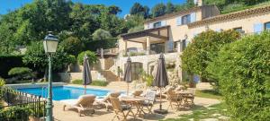 a villa with a pool and chairs and umbrellas at Loup Castel Boutique Hotel B&B in Le Bar-sur-Loup