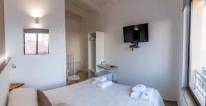 a bedroom with a bed and a tv on the wall at Il vicolo di Clara B&B in Diamante