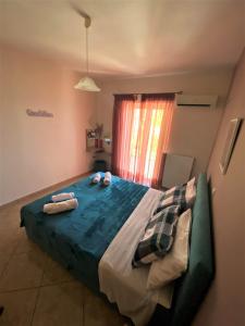 a bedroom with a large bed with towels on it at Lasithiotakis Apartments in Póros Kefalonias