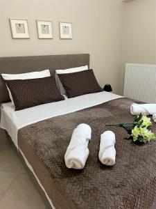 um quarto com uma cama com toalhas brancas em Lasithiotakis Apartments em Póros