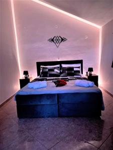 een slaapkamer met een groot bed met verlichting bij Lasithiotakis Apartments in Póros