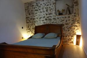 Cama en habitación con pared de piedra en Maison avec Suite Justice Argeles sur Mer en Argelès-sur-Mer