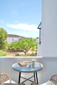 a table on a balcony with a view of the ocean at Dorkas Luxury Rooms&Apartments in Livadakia