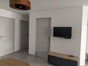 a living room with a flat screen tv on a wall at Appartement moderne dans village de charme in Salviac