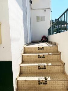un conjunto de escaleras frente a un edificio en Casa Faroleiro en Nazaré