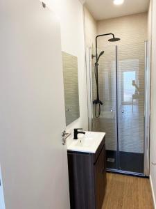 a bathroom with a sink and a shower at Casa Faroleiro in Nazaré