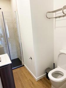 uma casa de banho com um WC e uma cabina de duche em vidro. em Casa Faroleiro na Nazaré