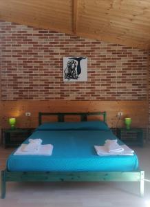a bedroom with a blue bed in a brick wall at Agriturismo Sentiero delle Fiabe in Sirolo