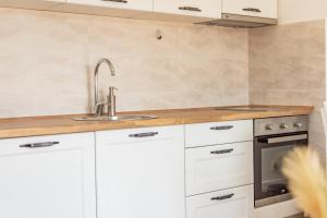 a kitchen with white cabinets and a sink at Zeleni in Đenovići +43 photos