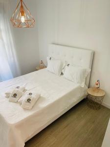 Una cama blanca con dos toallas encima. en Casa Cândinha en Nazaré