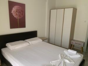 a bedroom with a white bed and a painting on the wall at Zeusplace NewWave Deluxe Apartment in Paralia Katerinis