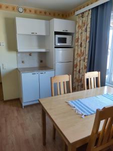 a kitchen with a wooden table and a table and chairs at Marent Apartments in Salo