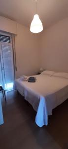a bedroom with a large bed with a white blanket at CASA VACANZA IL BALCONCINO in Bergamo