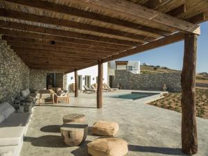 une terrasse avec une pergola en bois et une piscine dans l'établissement Casa Botanica Luxury Villas Antiparos, à Andiparos