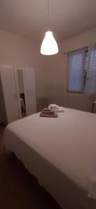 a bedroom with a large white bed with towels on it at CASA VACANZA IL BALCONCINO in Bergamo