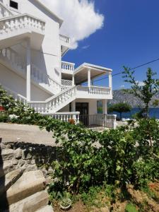 a white house with stairs and a balcony at Apartments Popovic in Kotor