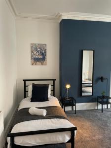 a bedroom with a bed with blue walls and a mirror at Balfour B - Fully refurbished 2 bedrooms Ideal for Contractors and Families Free wifi Free Parking Ground Floor in Gateshead