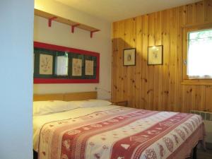 um quarto com uma cama com um cobertor vermelho e branco em HAMEAU DES HUSKIES em Saint-Gervais-les-Bains