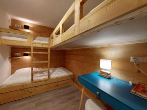 a bedroom with two bunk beds and a blue desk at Appartement Les Arcs 1800, 3 pièces, 7 personnes - FR-1-346-313 in Arc 1800
