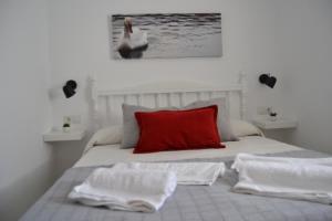 um quarto com uma cama com uma almofada vermelha e um cisne em J&V Apartamento em Ronda