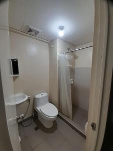 uma casa de banho com um WC, um chuveiro e um lavatório. em A’s Condo em Iloilo