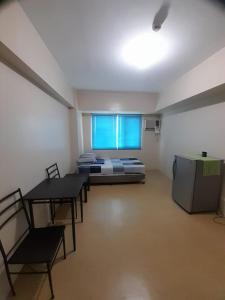 a room with a bed and a table and chairs at A’s Condo in Iloilo City +16 photos