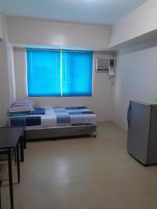 Habitación pequeña con cama y ventana en A’s Condo en Iloílo