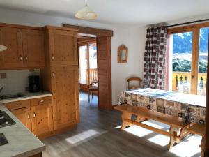 a kitchen with wooden cabinets and a table in a room at Montana 3 in Pralognan-la-Vanoise