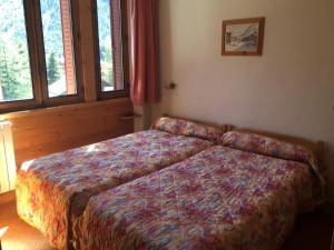 a bedroom with a bed in a room with windows at Montana 3 in Pralognan-la-Vanoise