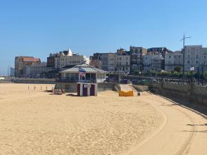 a sandy beach with buildings in the background at Walpole Bay Apartment in Cliftonville