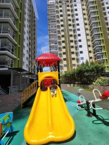 a playground with a yellow slide in front of some buildings at The Marys Place-Cozy&Modern Fully Furnished StudioType Condo at MesaVerte Residences in Cagayan de Oro