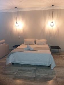 a bedroom with a large bed with two lights at Guest house on Gillian Unit 7 in Ballito